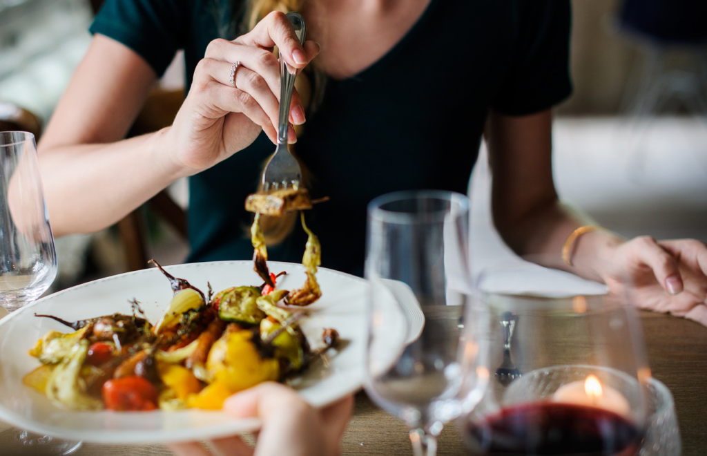 A woman is getting the food with a fork.