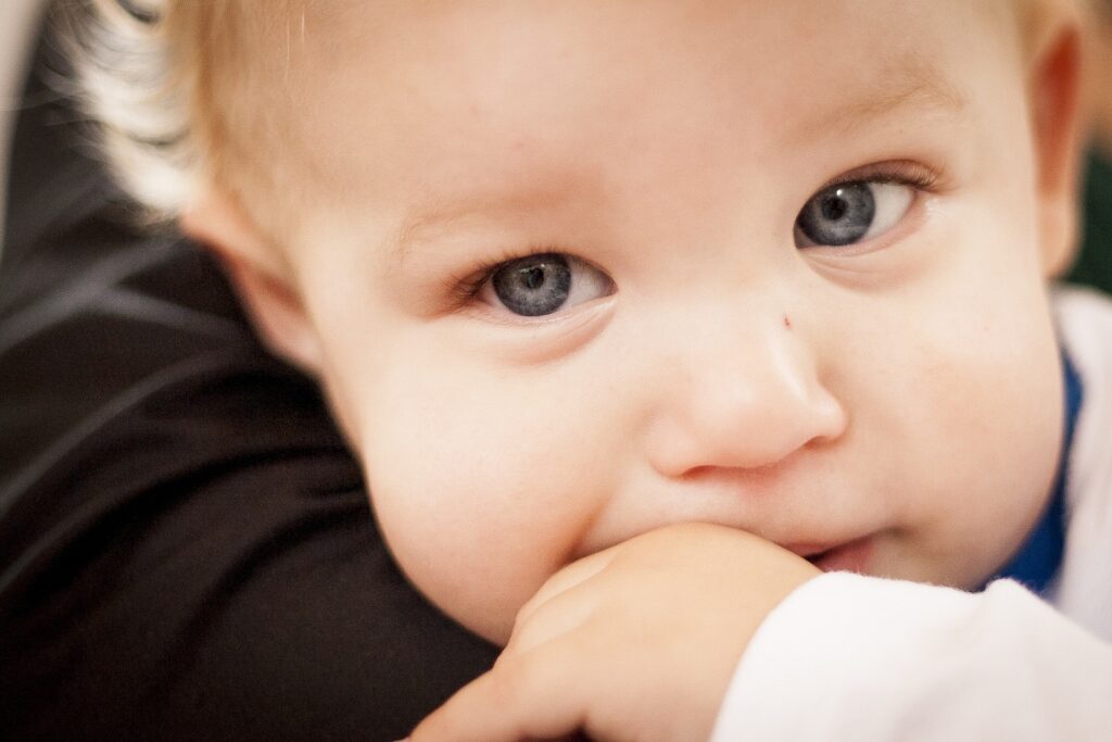 A cute baby is sucking his finger