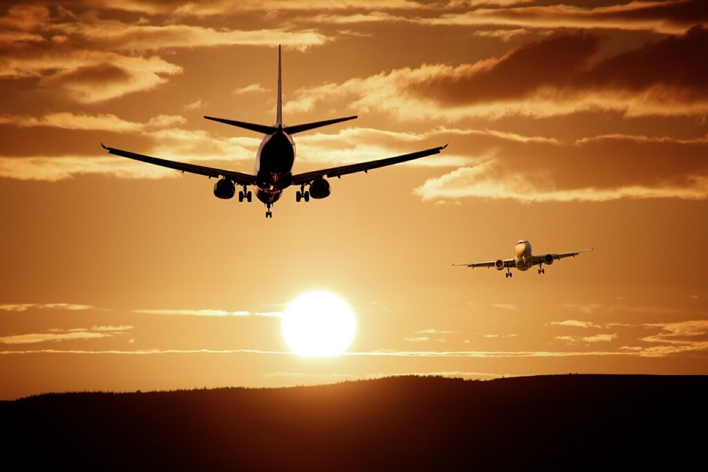 Plane flying in the sky with dark orange color.