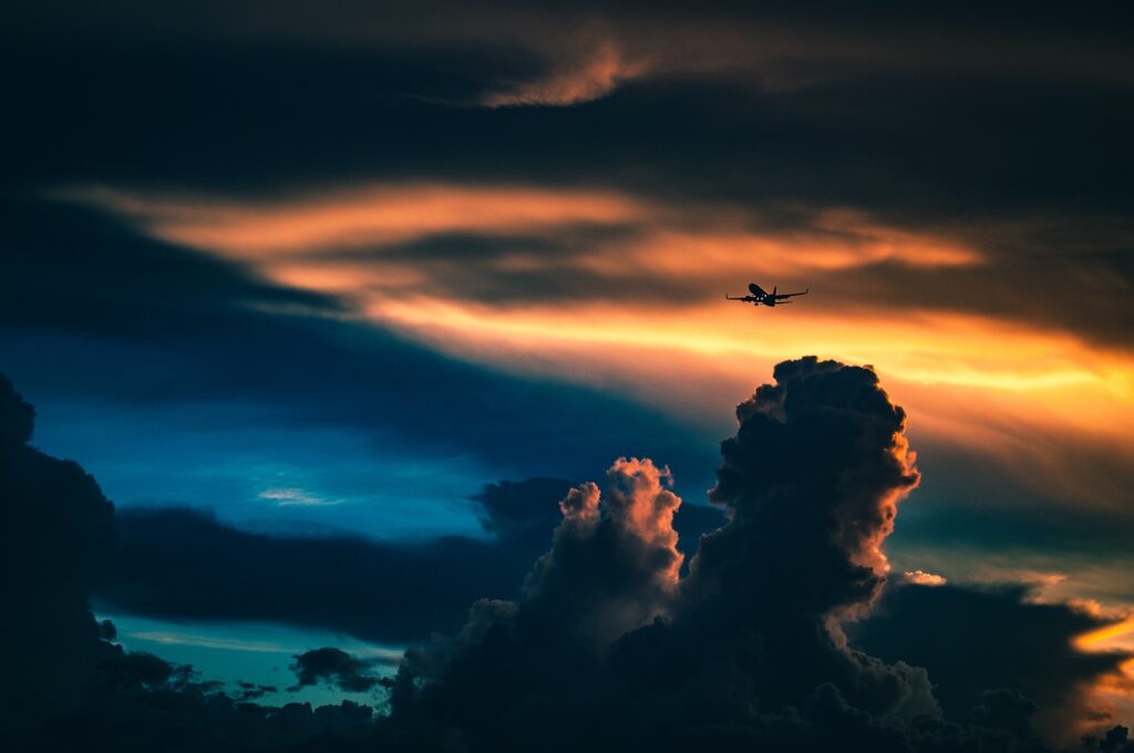 A plane is flying above the heavy clouds
