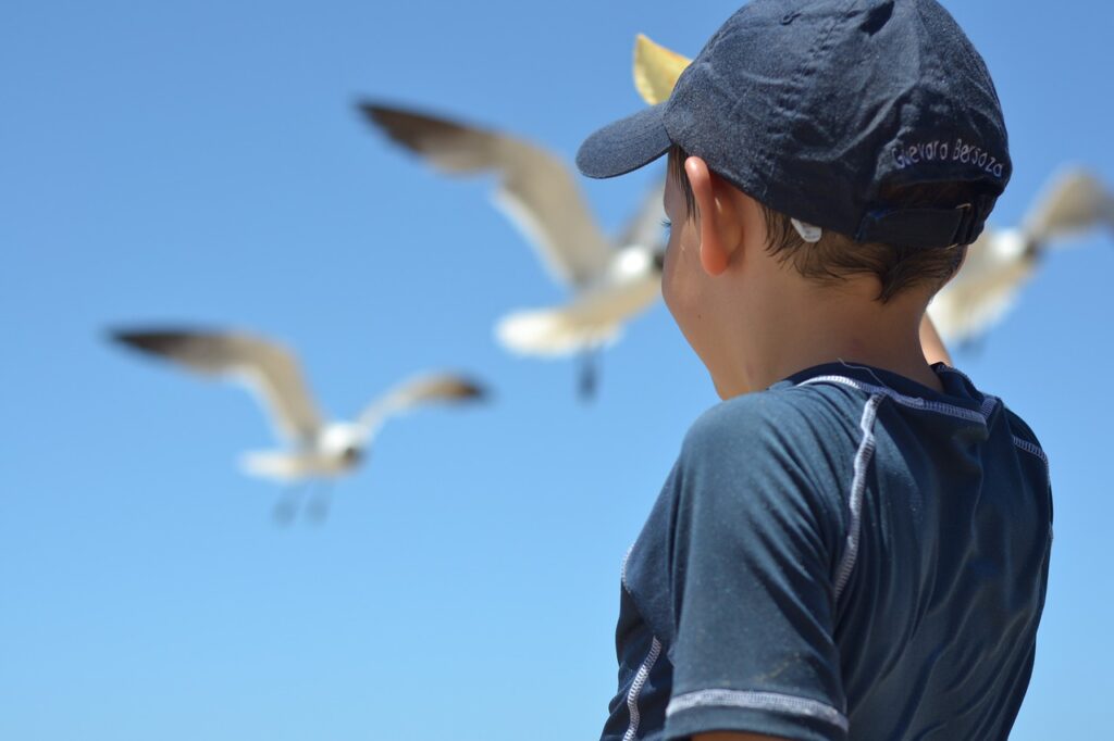 A boy is looking at the blue sky.